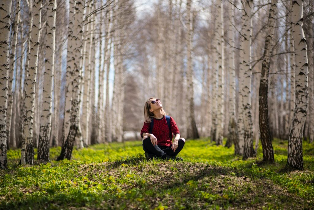 Eine Frau, die in einem kleinen Wald sitzt